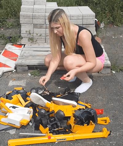 girl crushing toy car with socks and sneakers, burning her shoes